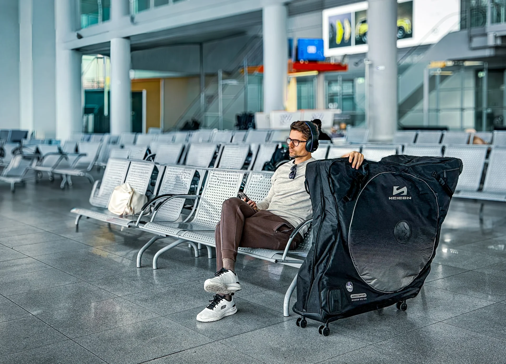 Podróżny z walizką rowerową Scicon Aerocomfort na lotnisku